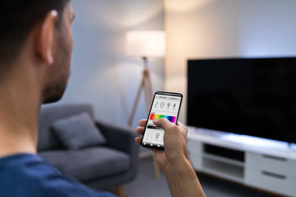 istock Human Hand Adjusting Electric Light Through Mobile Phone 1191071298