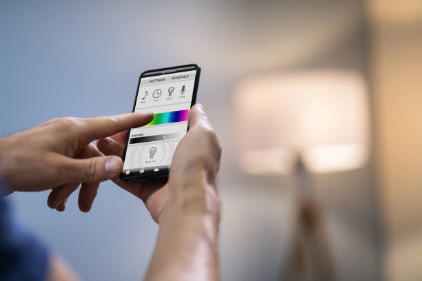 istock Human Hand Adjusting Electric Light Through Mobile Phone 1191071310