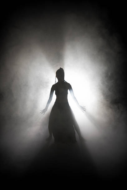 istock Silhouette dancer woman performing dance figures in fog. 1191072068