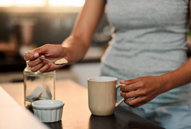 Something to sweeten the day Cropped shot of a woman making a cup of coffee at home spoon photos stock pictures, royalty-free photos & images