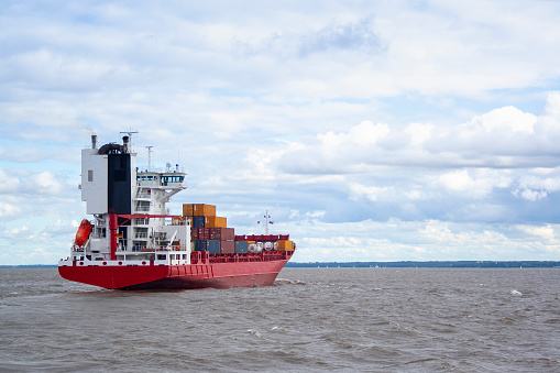 huge red barge with large containers on board. shipping cargo transportation by sea