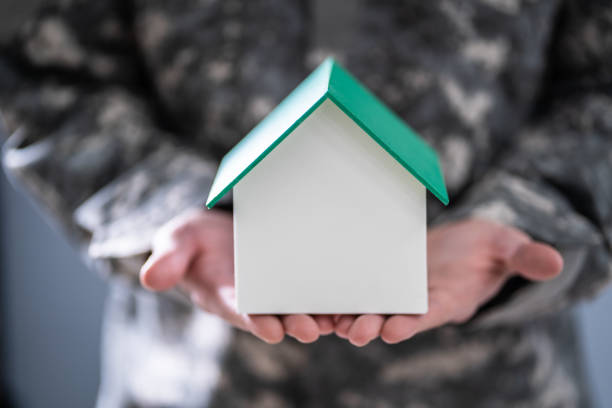 istock Soldier Holding Model House In Hand 1191081115