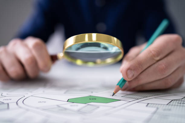 istock Human Hand Holding Pencil Over Cadastre Map 1191081803