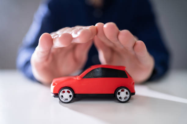 istock Businessman's Hand Protecting Red Toy Car 1191082083
