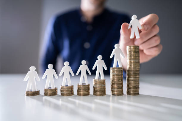 istock Human Hand Placing Human Figure On Increasing Stacked Coins 1191082084