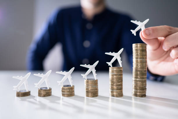 istock Human Hand Placing Small Airplane On Increasing Stacked Coins 1191082091
