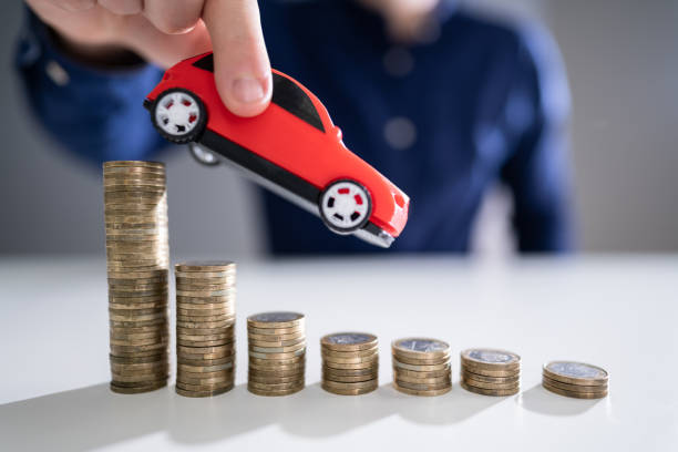 istock Person Flying Car Over Declining Stacked Coins 1191082098