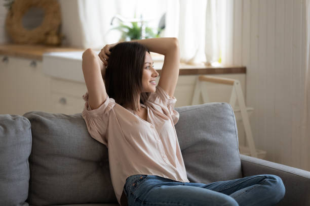 istock Relaxed lazy lady holding hands behind head lounge on sofa 1191083743