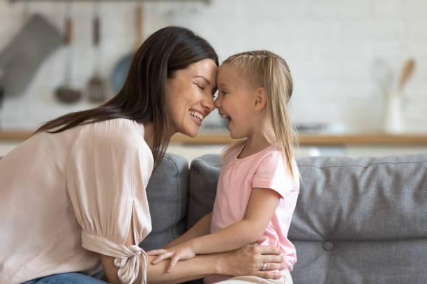istock Happy mother having fun with cute kid daughter on sofa 1191083772