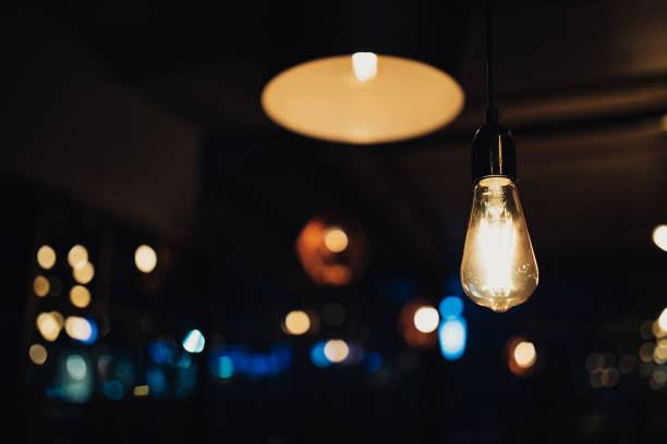 istock Vintage luxury interior blurred or defocused lighting decor in cafe. old Vintage light bulb lamps. Restaurant Bar lighting interior design. Vintage Light bulbs at wine chamber in front of alcoholic drinks bottles 1191084514