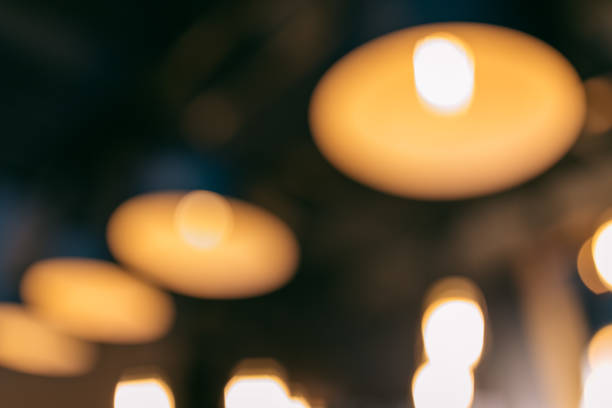 istock Vintage luxury interior blurred or defocused lighting decor in cafe. old Vintage light bulb lamps. Restaurant Bar lighting interior design. Vintage Light bulbs at wine chamber in front of alcoholic drinks bottles 1191087513