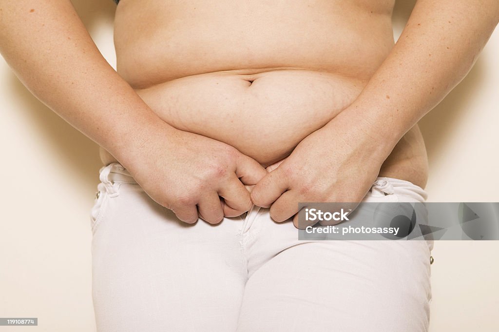 Overweighted mulher puxando sua calça de desconto - Foto de stock de Abdômen Humano royalty-free