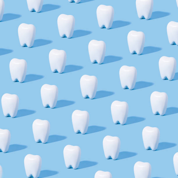 White teeth pattern on a blue paper background. White teeth pattern on a blue paper background. dental light stock pictures, royalty-free photos & images