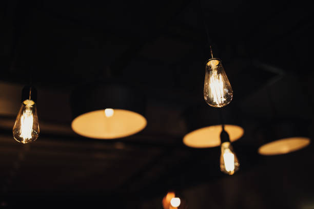 istock Vintage luxury interior blurred or defocused lighting decor in cafe. old Vintage light bulb lamps. Restaurant Bar lighting interior design. Vintage Light bulbs at wine chamber in front of alcoholic drinks bottles 1191092647
