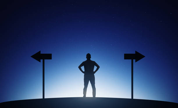 Young man standing choosing direction stock photo