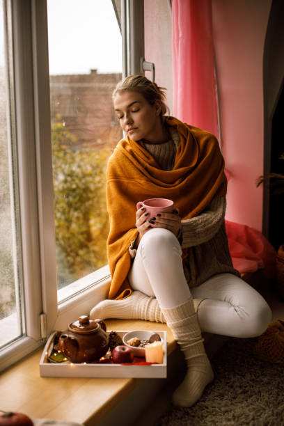 istock Enjoying warm cup of tea on a window cell 1191111371