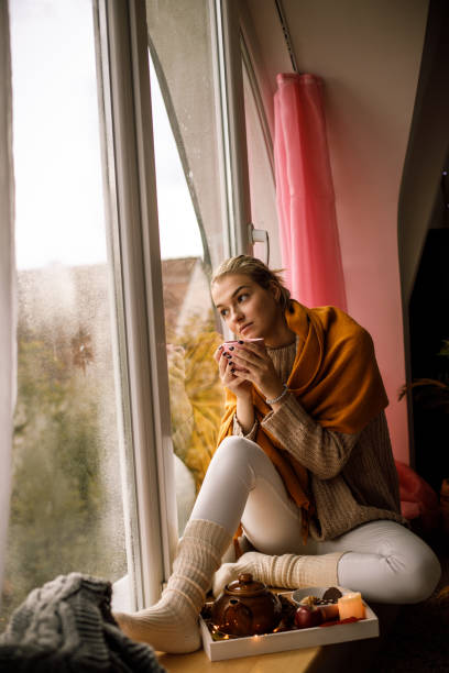 istock Reminiscing and looking through the window on a cold autumn day 1191111372