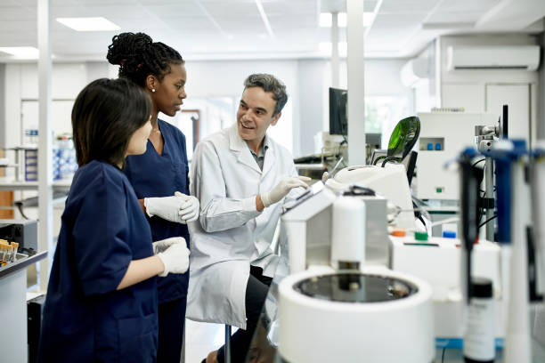 istock Male Pathologist Working with Female Technicians in Lab 1191113990