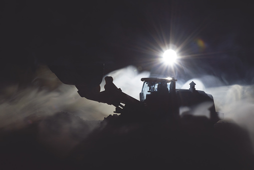 Tractor is working on the construction site at night concept.