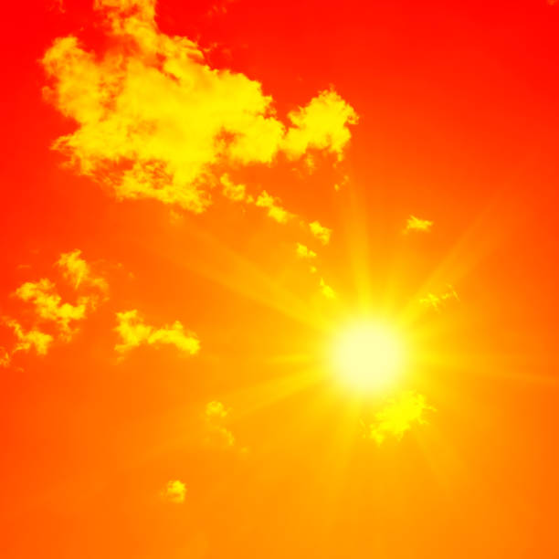 istock Bright sun with beautiful beams in the sky with clouds (toned in red) 1191121584