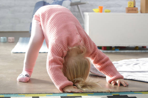 istock Two years old toddler girl learning to roll forward 1191126500