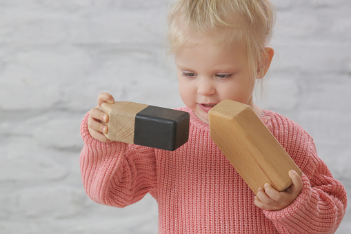 Toddler girl playing with wooden blocks