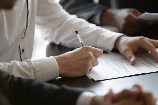 Close up young male manager hands signing contract. Close up young male employee manager customer hands signing paper contract after checking. Millennial investor client put signature at business agreement between partners. Editor making corrections. personal loan stock pictures, royalty-free photos & images