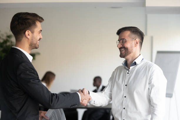 istock Two smiling business partners shaking hands with each other. 1191132461