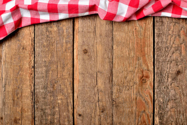 istock Red checkered tablecloth top frame on vintage wooden table background - view from above 1191132652