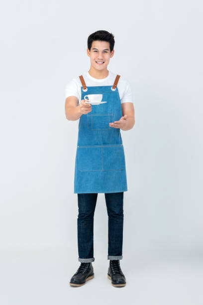 Handsome smiling service minded Asian man barista serving a cup of coffee
