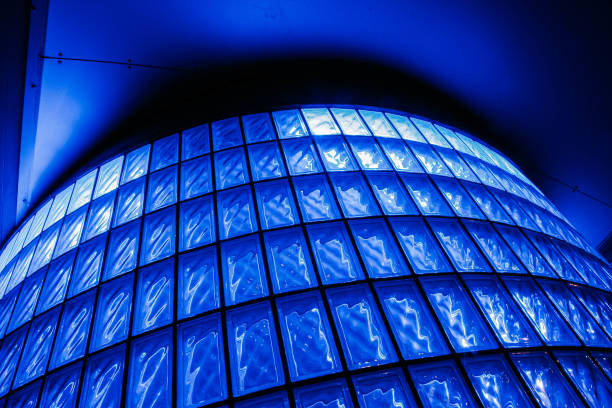 Low angle shot of a glass brick circular wall back lit with blue light creating a nice pattern. Glass brick is used for light and decoration.These double layered bricks are used for more light in a house project.