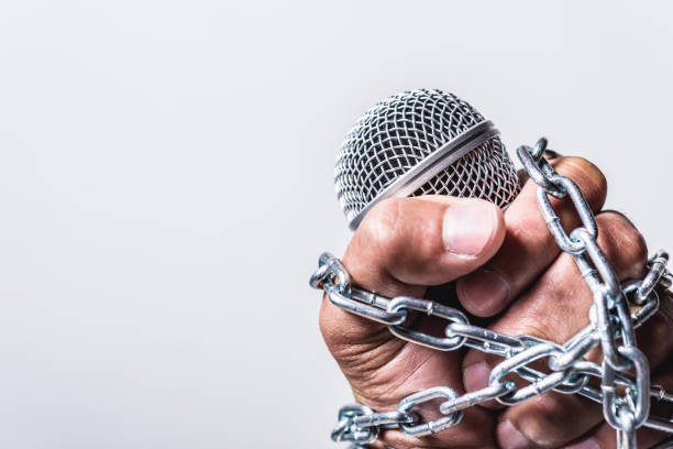 istock Hand holding microphone and have chain on fist hand on white background 1191136768