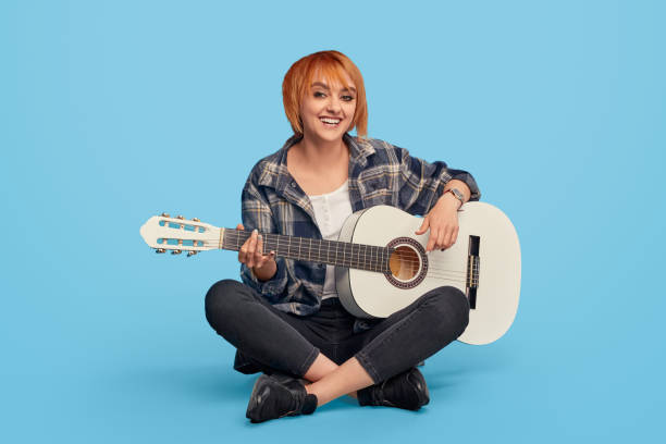 istock Excited woman smiling playing guitar 1191142927
