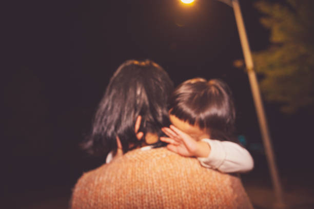 A daughter and mother walk in dark street at nigt