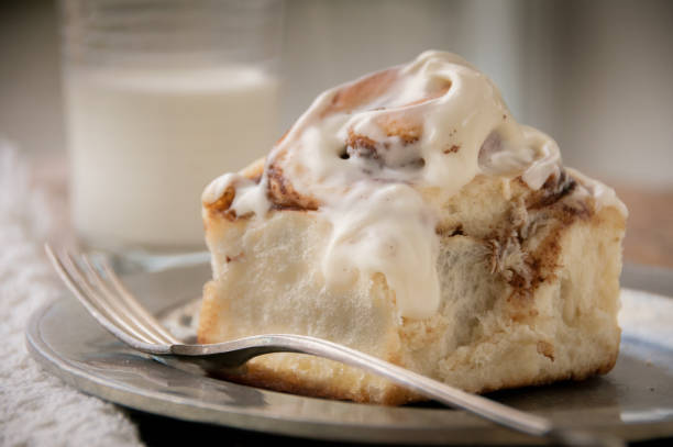 シナモンパンロールアイシング付き - cinnamon bun icing pastry ストックフォトと画像