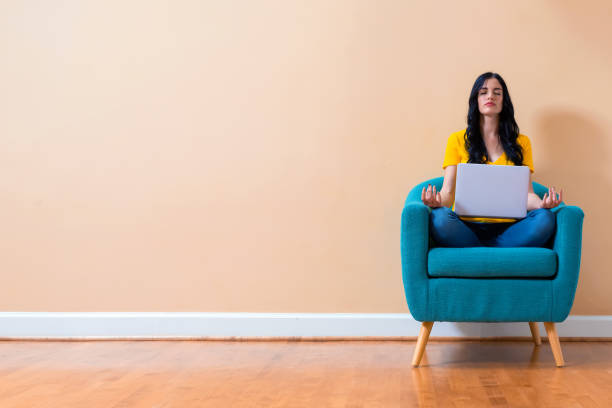 istock Young woman with laptop in a meditation pose 1191152728