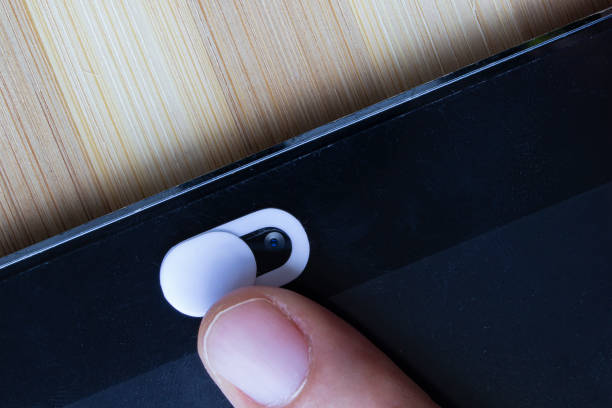 A White Color Camera Privacy Cover. Slide Webcam. Cover for an electronic device with a finger.