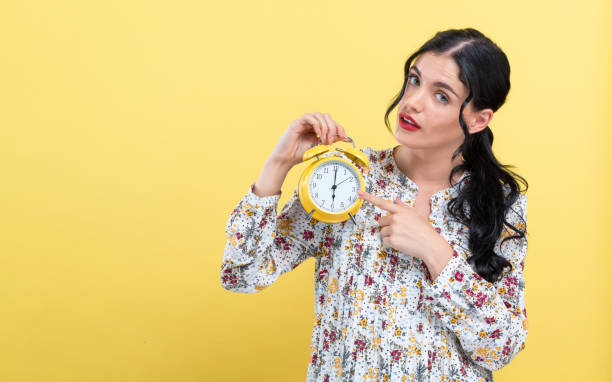 istock Yong woman holding a clock showing 6AM 1191161264