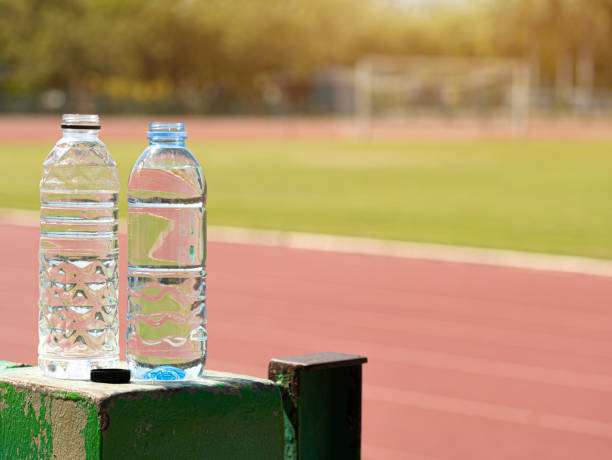 two bottles of clear water placed beside the football field. - football player imagens e fotografias de stock