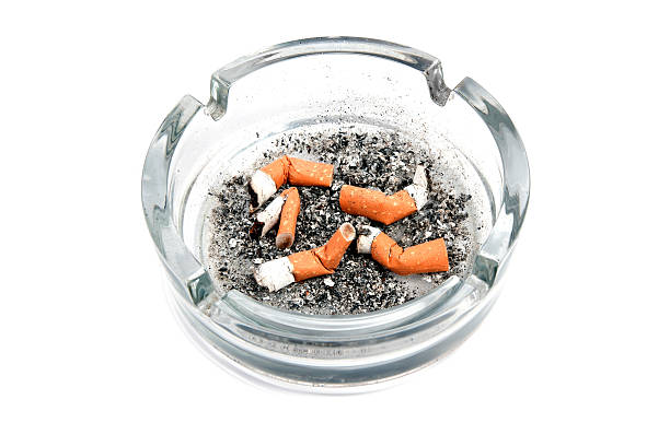 istock Glass ashtray with 5 cigarette buds isolated on white background 119116638