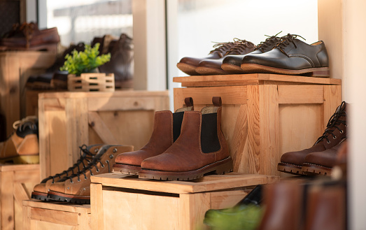 Men fashion shoe boots on the wooden box in the store. Retail shopping