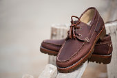 Men fashion leather boat shoes on wooden background. Fashion advertising shoes photos.