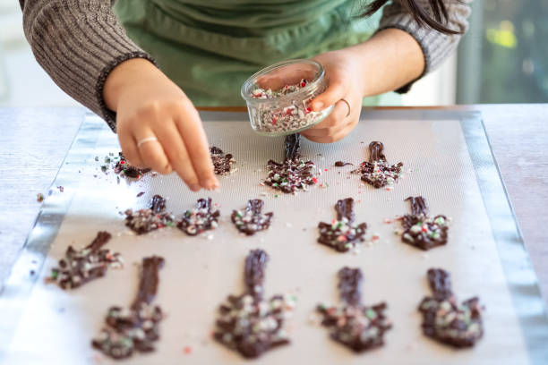 istock Home Baker Decorating Chocolate Christmas Trees with Crushed Candy Cane 1191176263