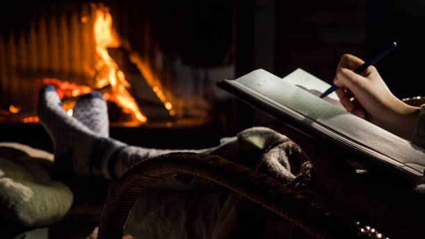 istock A man begins to write on a blank page of a notebook, sits by the fireplace 1191182105