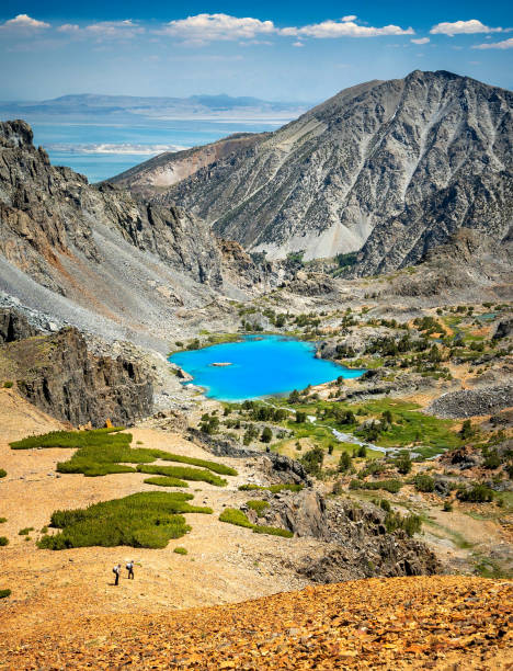 Little Lakes Valley hiking trail in the Eastern Sierra Nevada Mountains. Beautiful alpine pond with a reflection of snow capped mountains in summer