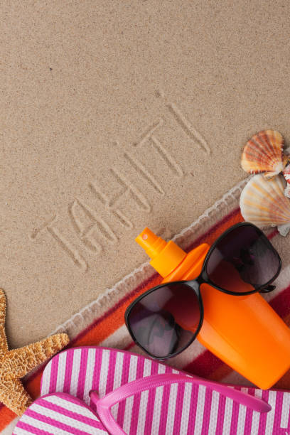 istock Word TAHITI written in sand with beach accessories. 1191185490