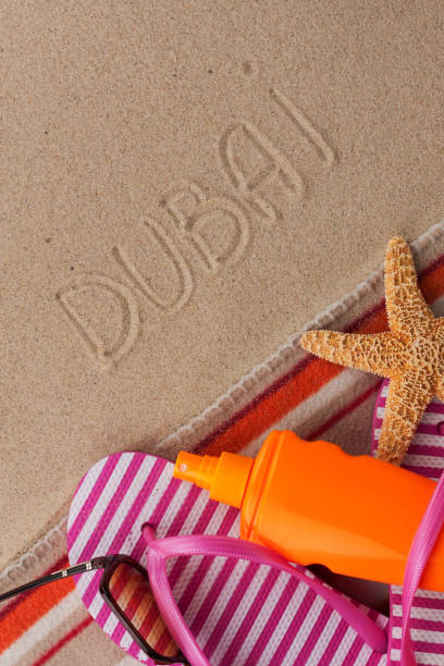 istock Word DUBAI written in sand with beach accessories. 1191185508