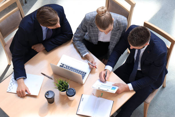 top view of buiness team brainstorming while sitting at the office table together. - 2271 imagens e fotografias de stock