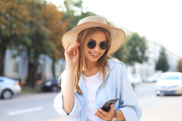 istock Beautiful young blonde girl using mobile phone while standing outdoors. 1191190059