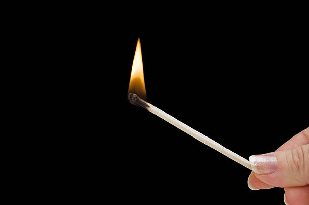 istock Hand holding burning match stick on black 119119084